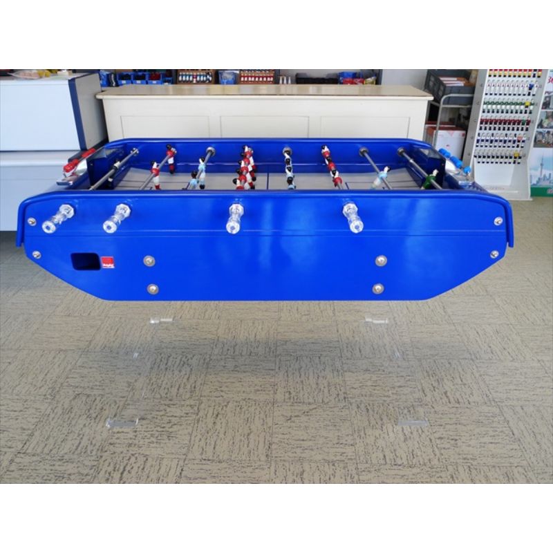 Blue foosball table with chrome handles in a game room setting