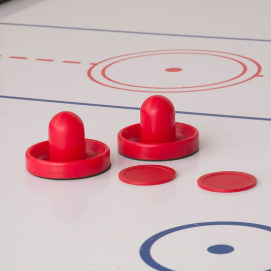 Red air hockey paddles and pucks on a white air hockey table